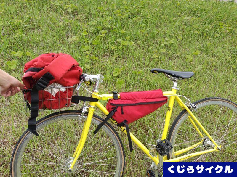 自転車 前かごに積まれた赤いメッセンジャーバッグ